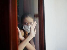 Frau gekreuzt ihr Waffen im Vorderseite von ihr im Quarantäne Verbot Fenster foto