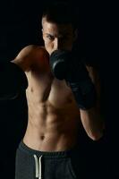Sport Kerl auf ein schwarz Hintergrund im Boxen Handschuhe aufgeblasen Torso abgeschnitten Aussicht foto