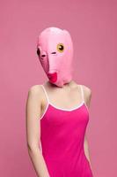 sehr seltsam Frau im ein Rosa Silikon Fisch Maske zum Halloween, verrückt Bild im Rosa Kleider foto