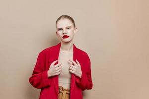 modisch Frau rot Lippen Mode Jacke Beige Hintergrund foto