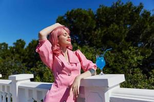 glamourös Frau Trinken ein Cocktail auf das Terrasse unverändert foto