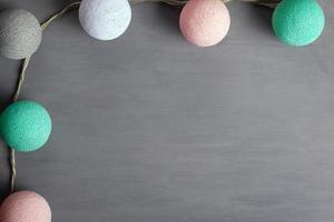 Girlande mit bunten Bällen der Pastellfarben der Baumwolle auf einem grauen Hintergrund foto