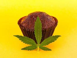 Schokoladen-Muffin-Kuchen mit Marihuana auf gelbem Hintergrund foto