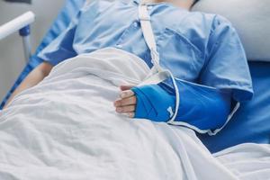 verletzt geduldig zeigen Arzt gebrochen Handgelenk und Arm mit Binde im Krankenhaus Büro oder Notfall Zimmer. Verstauchung, Stress Fraktur oder repetitiv Belastung Verletzung im Hand. Krankenschwester Portion Kunde. zuerst Hilfe. foto