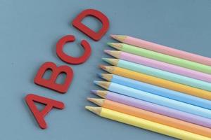 zurück zu Schule Konzept mit sortiert Briefe und farbig Bleistifte im Pastell- Farben foto
