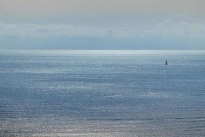 Ruhe Blau Strand Landschaft mit Wasser und Himmel und Segelboote foto