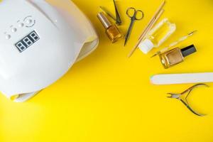 Satz Werkzeuge für Maniküre und Nagelpflege auf gelbem Grund foto