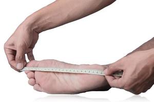 Nahansicht von ein Mann Messung Fuß Größe mit ein Messung Band auf ein Ausschnitt Pfad Weiß Hintergrund foto