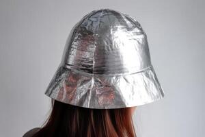 ein Person trägt ein klein handgemacht Hut gemacht von Aluminium vereiteln auf ein Licht Hintergrund zu schützen selbst von Strahlung und Verschwörung Theorie erstellt mit generativ ai Technologie. foto