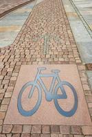Radfahren Fahrbahn zum Fahrräder gemacht im ein alt Stein Pflaster Straße mit ein Metall Zeichen von Fahrrad beim das Pfad und ein steinig Pfeil zeigen Richtung zum Radfahren im ein alt Deutsche Stadt. foto