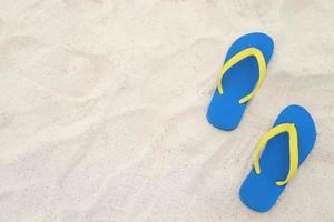 Meer am Strand Fußabdruck Menschen auf dem Sand und Pantoffel der Füße in Sandalen Schuhe auf Strandsand Hintergrund. Reiseferienkonzept. foto