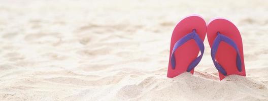 Meer am Strand Fußabdruck Menschen auf dem Sand und Pantoffel der Füße in Sandalen Schuhe auf Strandsand Hintergrund. Reiseferienkonzept. foto