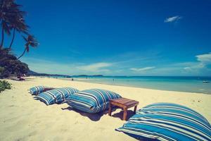 schöner tropischer Strand und Meer mit Stuhl auf blauem Himmel