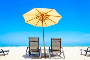 Sonnenschirm und Stühle am Strand foto