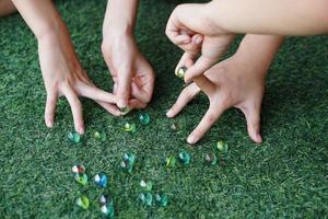Nahansicht Kinder Hände sind spielen Spiele mit klein Bälle. Konzept, traditionell Kinder spielen. Erholung Aktivität zu machen konzentrieren zum Kinder, Spaß und Wettbewerb Spiele foto