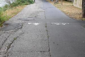 Fahrrad und Fußgänger Weg mit viel Beschädigung foto