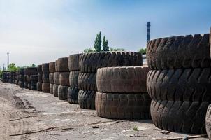 Stapel von ein alt Steinbruch LKW Reifen auf industriell Abfall Boden beim sonnig Tag foto