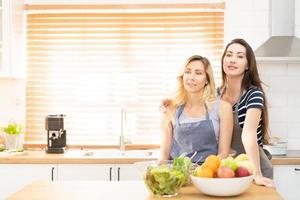 glücklich lgbt Lesben Paar Tanzen während Kochen zusammen beim heim. Mädchen Tanzen und drehen, genießen Zusammengehörigkeit beim Hintergrund Neon- Zeichen mit Wort zusammen. Konzept lgbt Paar. foto