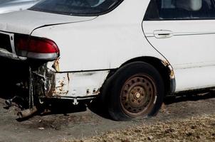 rostiges verlassenes auto mit platten rädern foto