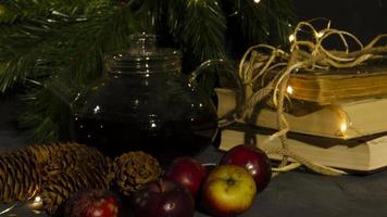 Glas Teekanne, alt Bücher, Kiefer Bäume und Äpfel. Girlande Beleuchtung. Nacht Bild. Weihnachten Stimmung. foto