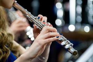 Hände halten ein Flöte. Mädchen Musiker Theaterstücke das Flöte. foto