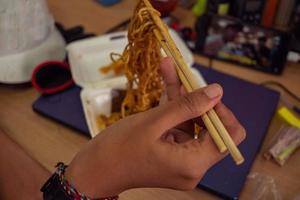 schließen oben Foto von traditionell würzig Nudel von Indonesien halt mit Stäbchen das Foto ist geeignet zu verwenden zum traditionell Essen Hintergrund, Poster und Essen Inhalt.