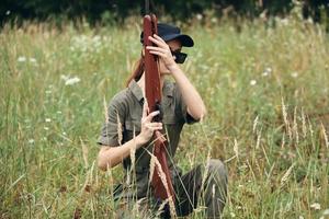 Frau Soldat mit ein Waffe im seine Hände dunkel Brille Schutz Grün Overall foto