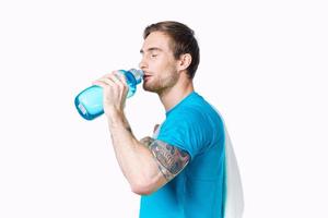 Sport Mann im Blau T-Shirt Wasser Flasche Durst abgeschnitten Aussicht foto