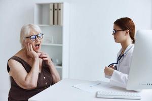 alt Frau geduldig reden zu ein Arzt Stethoskop foto
