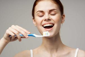 heiter Frau im Weiß T-Shirt Dental Hygiene Gesundheit Pflege isoliert Hintergrund foto