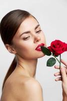 attraktiv Frau Körper hält ein Rose in der Nähe von das Gesicht von Luxus Pflege foto