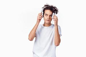 Teenager tragen Kopfhörer Neu Technologie Weiß T-Shirt isoliert Hintergrund Musik- Modell- foto