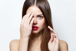 Frau mit lange Frisur Hand in der Nähe von das Augen Lippenstift foto