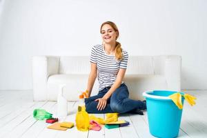 Reinigung Dame mit Eimer von Waschen liefert auf das Fußboden Innere Hausarbeit foto