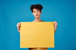 Kerl mit Gelb Poster im Hände Kopieren Raum Werbung Blau Hintergrund foto