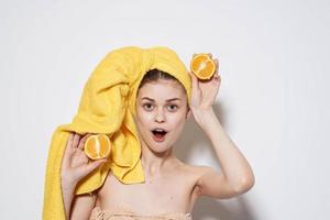 heiter Frau mit nackt Schultern Orangen halten ein Handtuch auf ihr Kopf mit sauber Haut foto