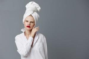 modisch Frau mit ein Handtuch auf seine Kopf im ein Weiß Hemd Studio Modell- unverändert foto