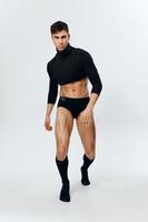 Porträt von ein Mann im voll Wachstum, aufgeblasen Torso Bodybuilder Fitness Unterhose und schwarz Sweatshirt Knie Socken foto