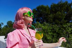 modisch Frau im Grün Sonnenbrille mit Cocktail im Sommer- draußen Entspannung Konzept foto