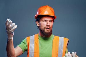 Mann im Orange Farbe schwer Arbeit Fachmann Blau Hintergrund foto