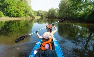 Familie Kajak Reise. Mama und Tochter Rudern ein Boot auf das Fluss, ein Wasser Wanderung, ein Sommer- Abenteuer. umweltfreundlich und extrem Tourismus, aktiv und gesund Lebensstil foto