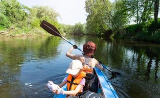 Familie Kajak Reise. Mama und Tochter Rudern ein Boot auf das Fluss, ein Wasser Wanderung, ein Sommer- Abenteuer. umweltfreundlich und extrem Tourismus, aktiv und gesund Lebensstil foto