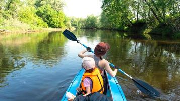 Familie Kajak Reise. Mama und Tochter Rudern ein Boot auf das Fluss, ein Wasser Wanderung, ein Sommer- Abenteuer. umweltfreundlich und extrem Tourismus, aktiv und gesund Lebensstil foto