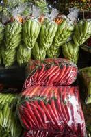 Stapel von Chili Pfeffer, verpackt im Plastik Taschen zum Verkauf im das Markt. foto