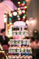 Hochzeit Cupcakes mit bunt Sträusel im Grün Tasse mit Girlande Beleuchtung Bokeh Hintergrund foto