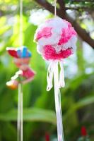 künstlich Rosa Blumen hängend und Lehm Puppe Dekoration auf Baum im Hochzeit. Hochzeit dekorativ im das Grün Garten draussen. foto