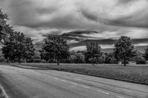 Sommer- Landschaft mit Grün Bäume, Wiese, Felder und Himmel mit Weiß Wolken und Beton Straße foto