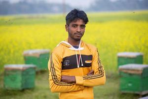 Bangladesch Januar 31, 2018 ein Arbeiter Auszüge Honig von ein Senf Blume und Anzeigen ein Biene Bienenstock von ein Bienenstock Box beim munshigonj, dhaka. foto