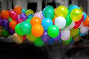 ein Bündel von bunt gasgefüllt Luftballons auf dunkel Hintergrund. foto