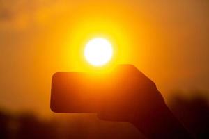 nehmen Bilder mit ein Handy, Mobiltelefon Kamera beim Sonnenaufgang. Selfie Picks oben mit ein Handy, Mobiltelefon Kamera im das golden Licht von Sonnenaufgang. foto